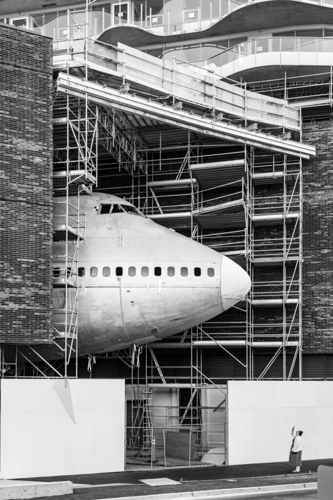 Close-up architectural detail of the Boeing 747 nose section emerging from the Aero1200 building facade in Seattle.
