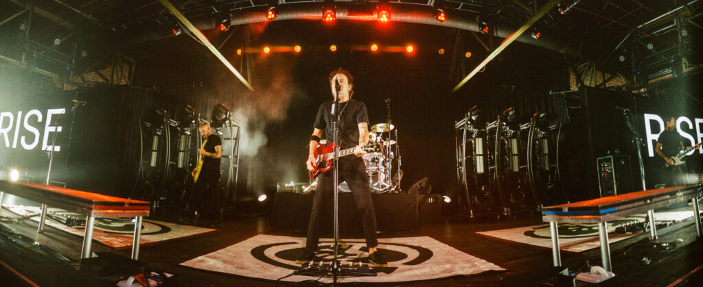 The band Rise Against captured on a panoramic photo shot with a widelux camera.